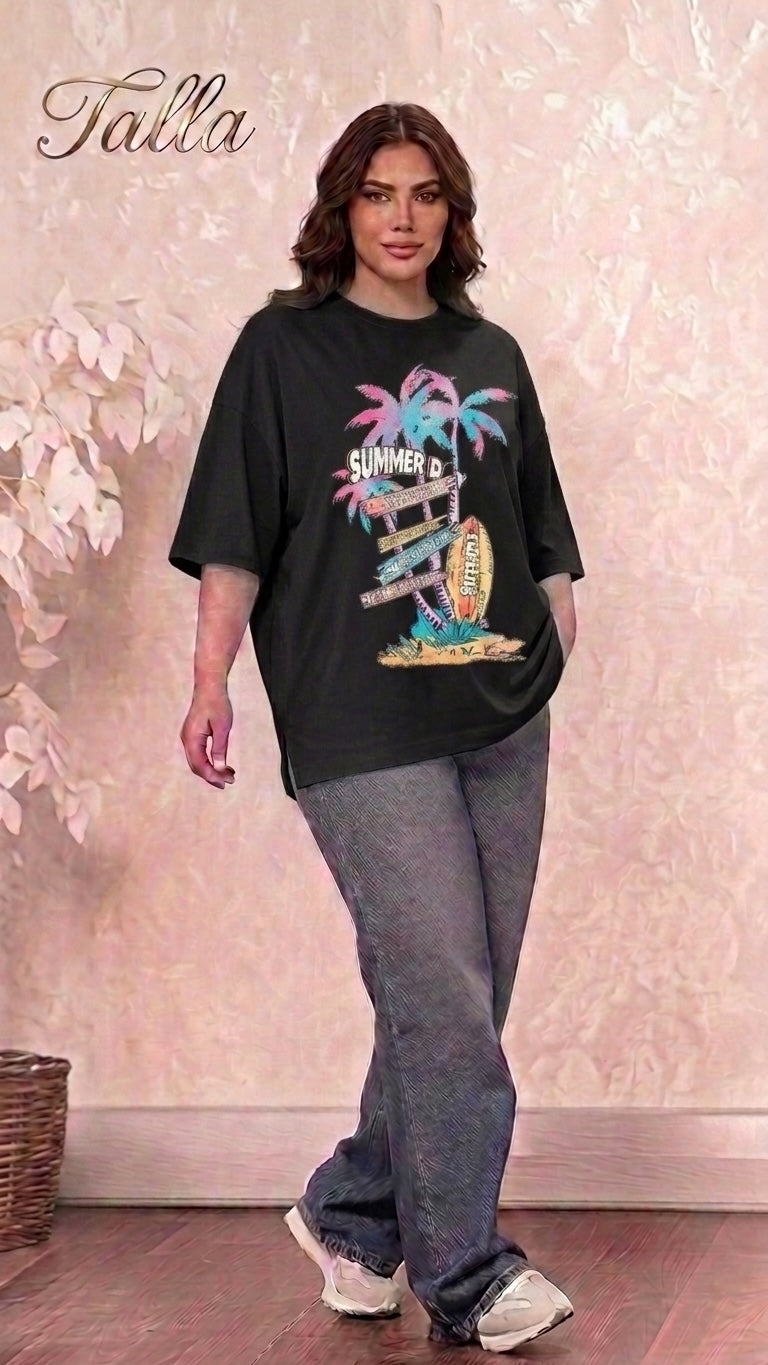 Model wearing a Talla | طلةّ black oversized graphic t-shirt with a summer beach print, styled with loose grey jeans.