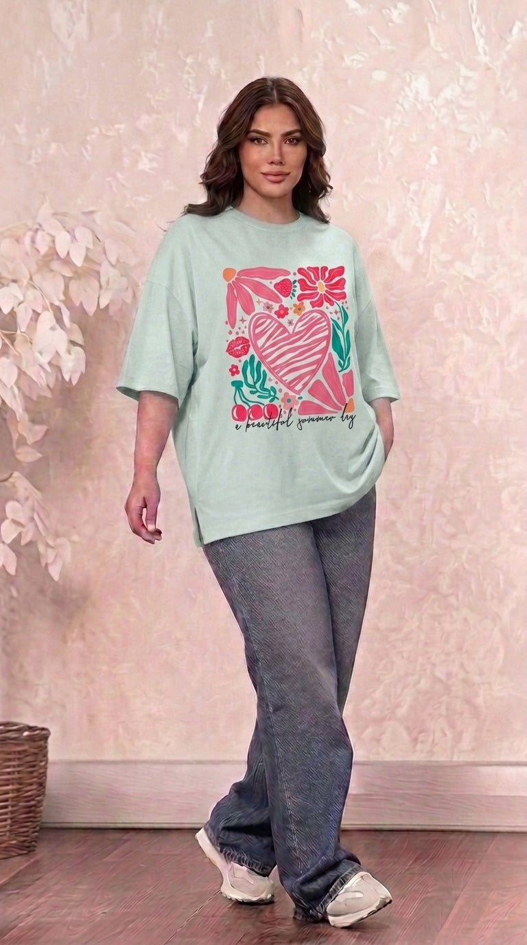 Talla | طلةّ oversized mint green graphic t-shirt with heart and floral print worn by a woman with jeans