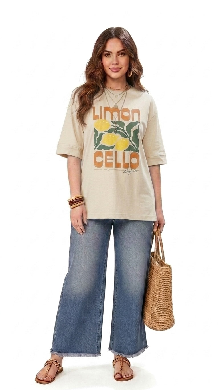 Talla | طلةّ beige oversized cotton t-shirt with Limoncello graphic print, worn with wide-leg denim and straw bag.