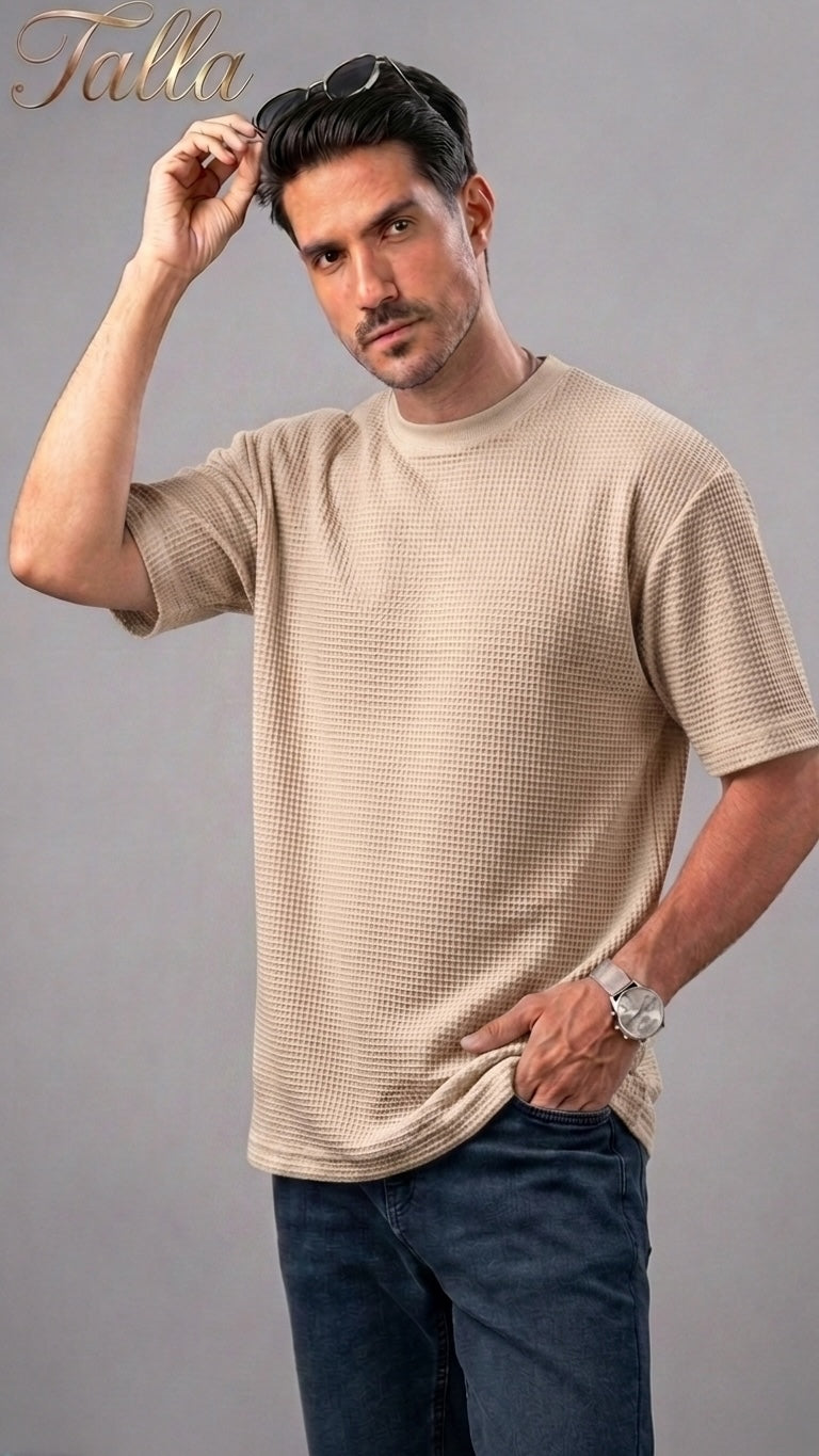 A man wearing a beige Talla | طلةّ waffle-knit crew neck t-shirt with a relaxed fit and short sleeves.