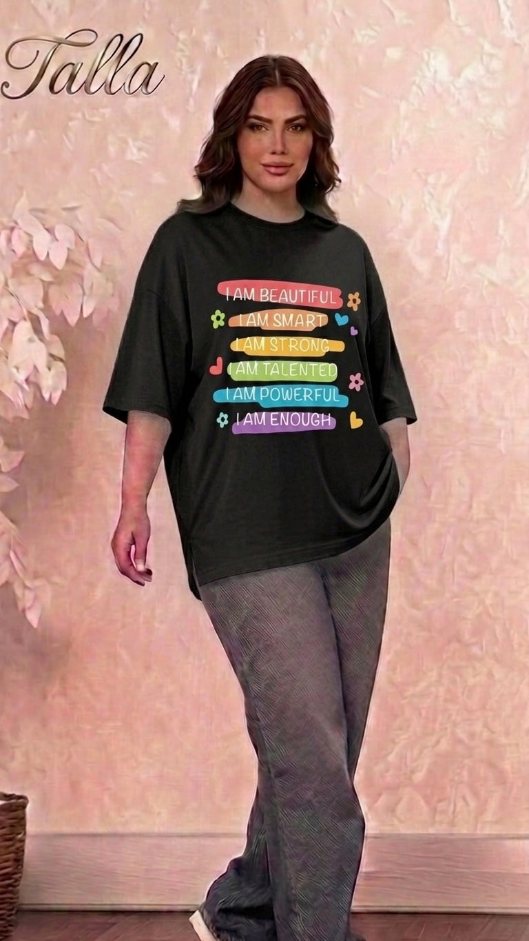 Model wearing a Talla | طلةّ black oversized cotton t-shirt with a colorful inspirational graphic print and side slits.