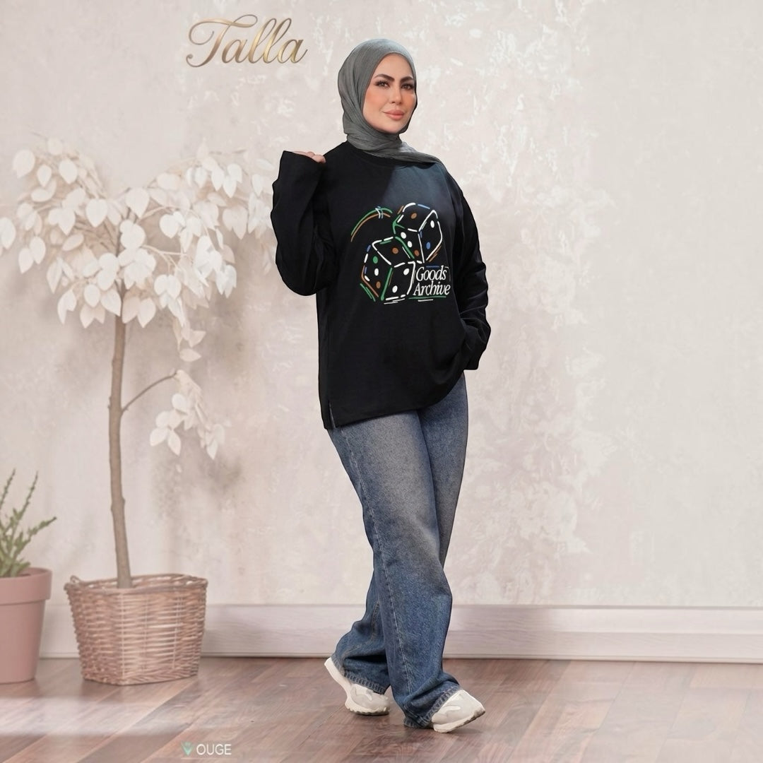 Talla | طلةّ black oversized sweatshirt with Goods Archive dice graphic, worn by a woman in a grey hijab and jeans.