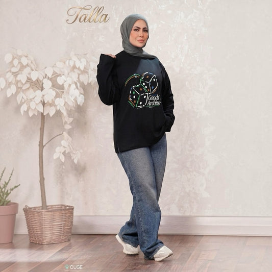 Talla | طلةّ black oversized sweatshirt with Goods Archive dice graphic, worn by a woman in a grey hijab and jeans.