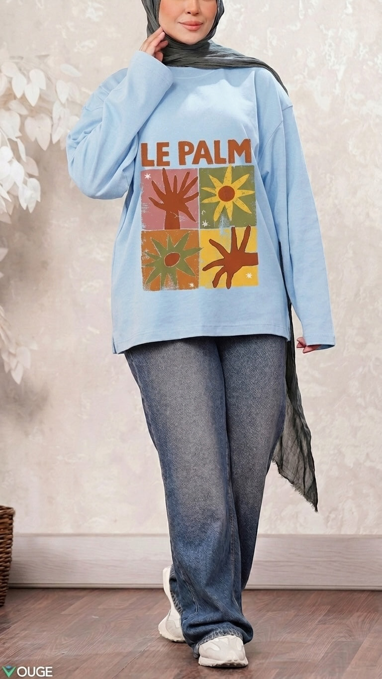 Talla | طلةّ light blue long-sleeve sweatshirt with Le Palm graphic print, worn by a model in a hijab and jeans.
