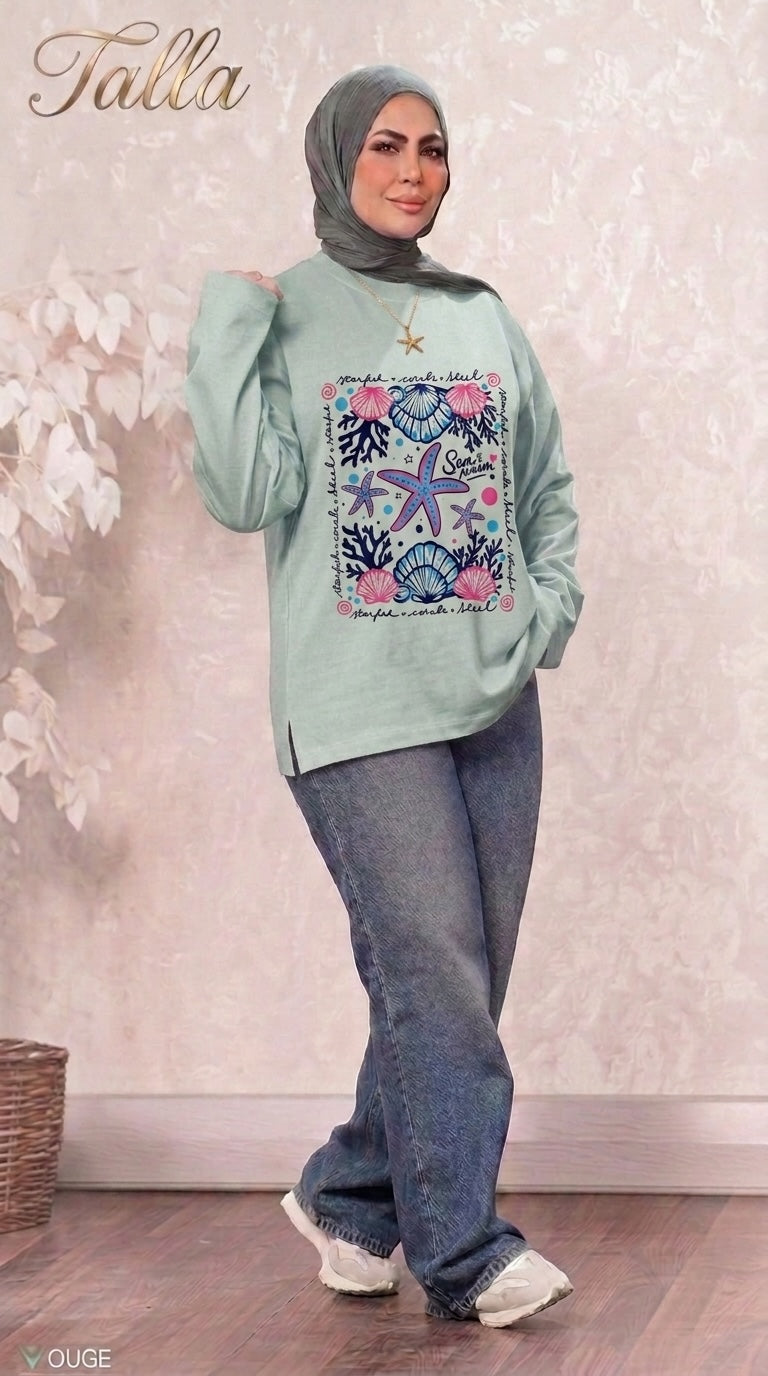 Talla | طلةّ mint green long sleeve sweatshirt with nautical starfish and seashell graphic print worn with blue jeans