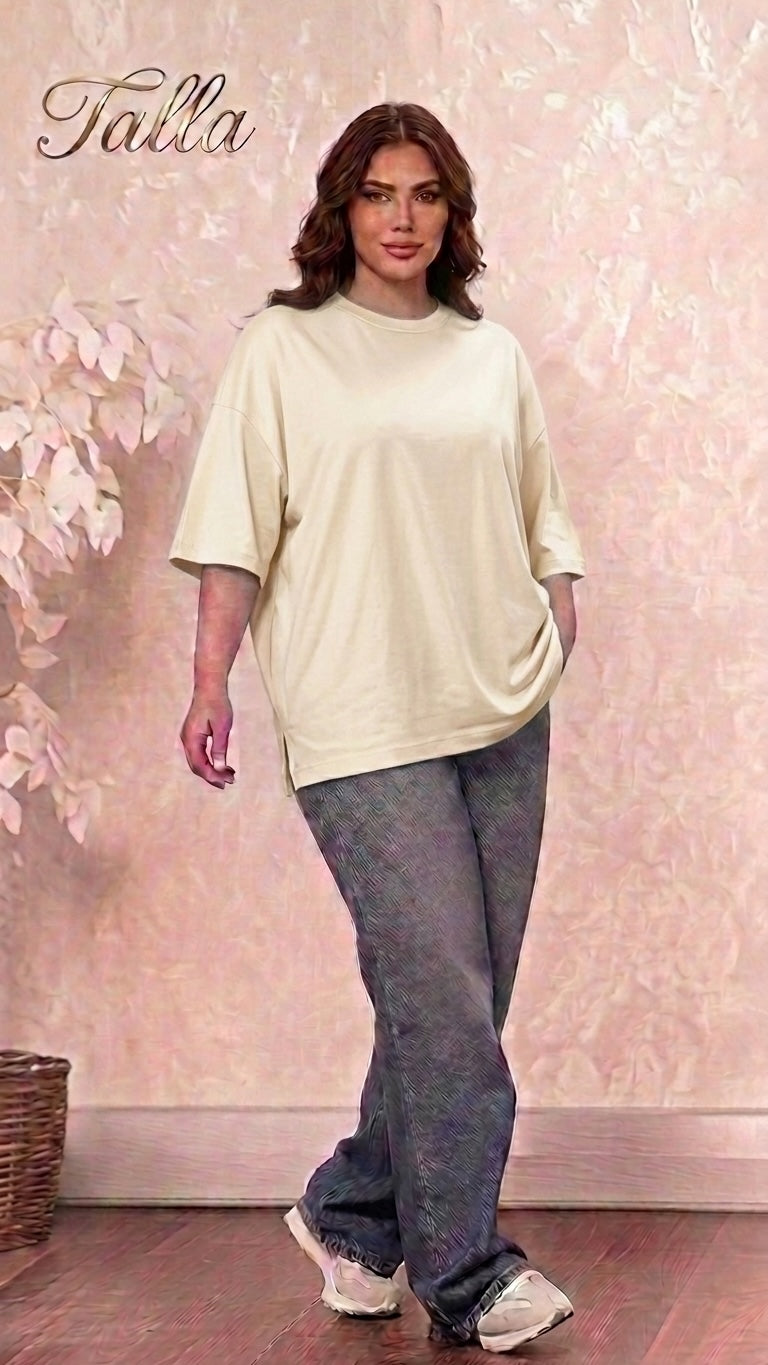Talla | طلةّ oversized beige crewneck cotton t-shirt with dropped shoulders and side slits worn by a woman.