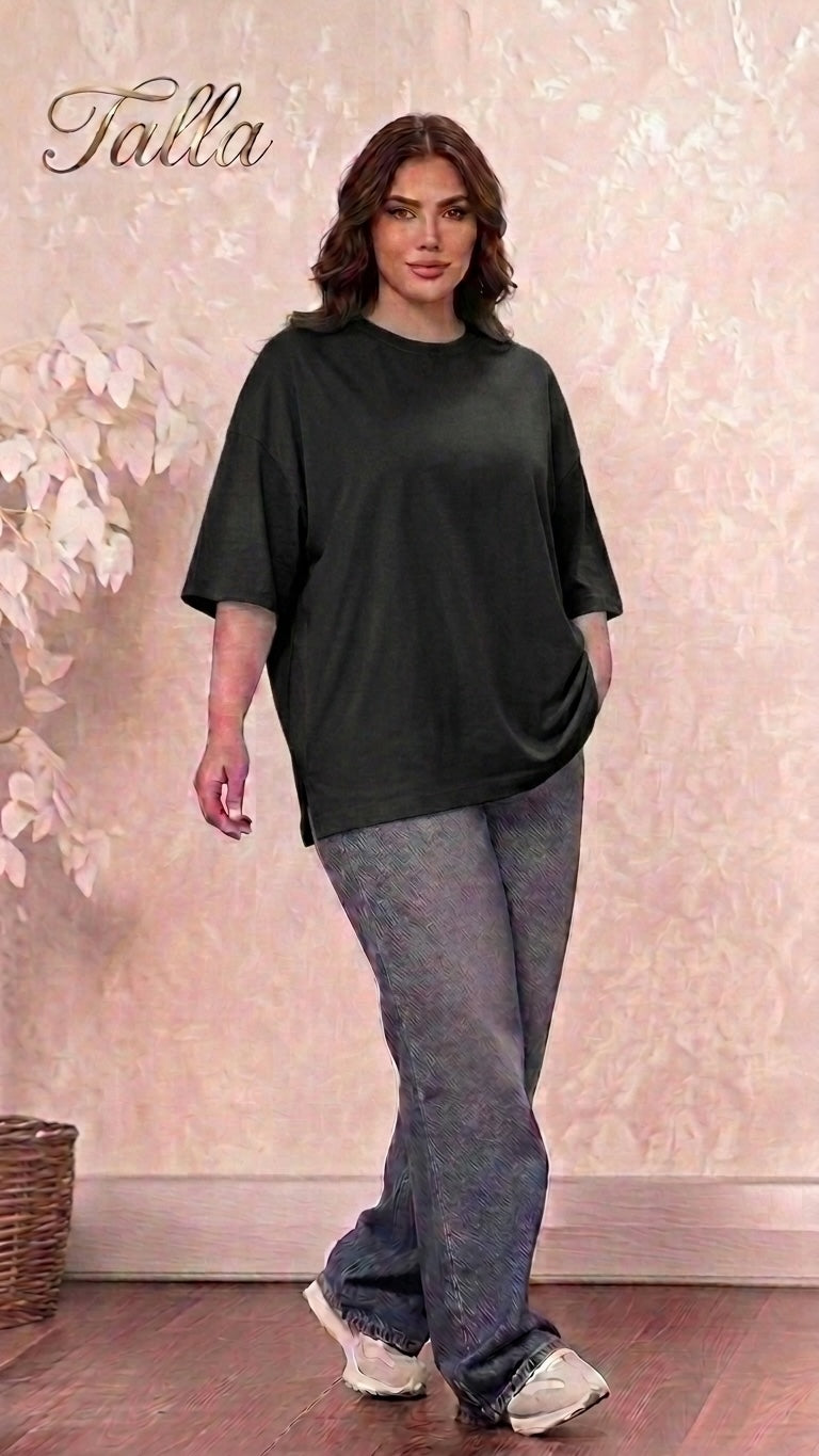 Model wearing a Talla | طلةّ oversized black cotton crewneck t-shirt with dropped shoulders and side-slit hem.