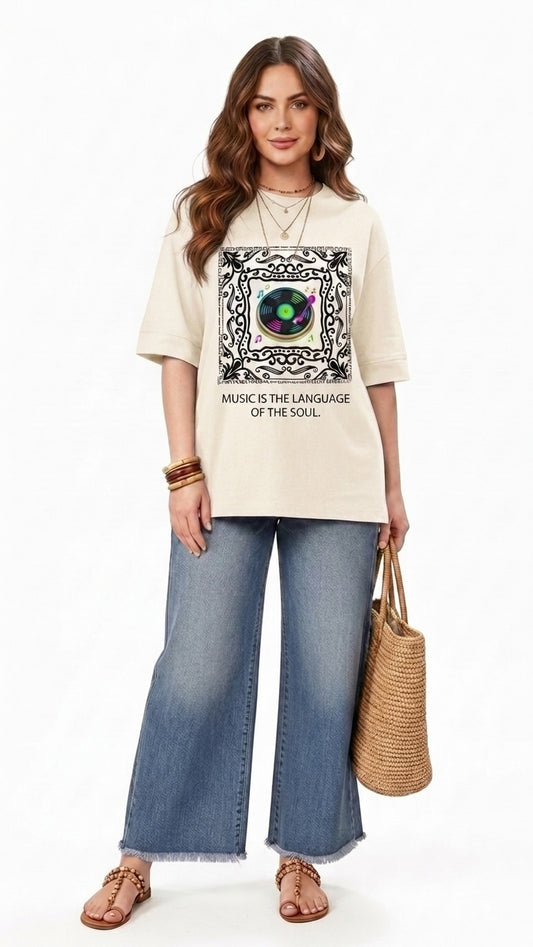 Talla | طلةّ oversized beige graphic t-shirt with a record player print and music quote, worn with wide-leg jeans.