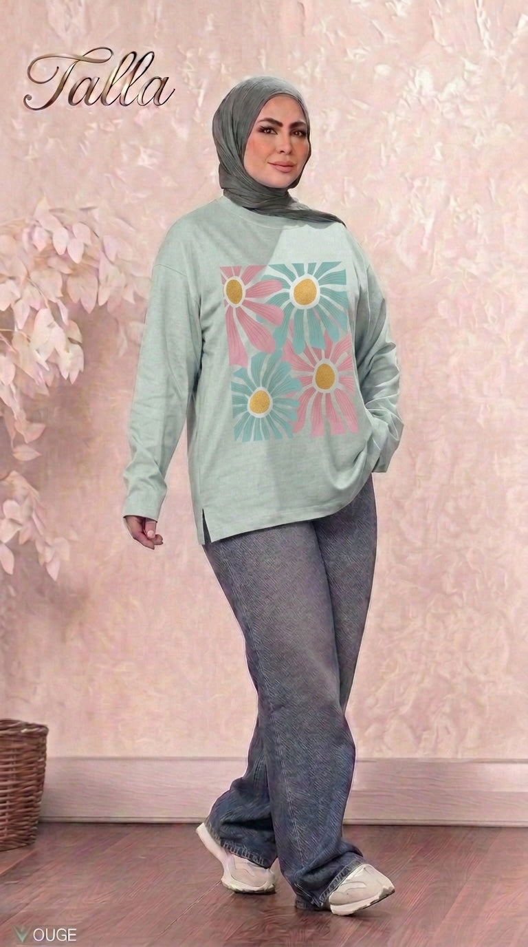 Talla | طلةّ sage green long sleeve sweatshirt with a floral graphic print, crew neck, and side slits worn with jeans