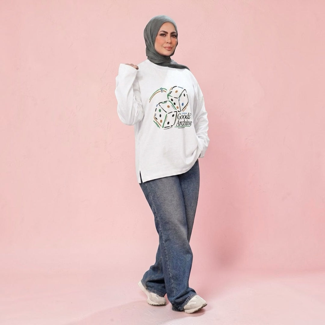 Talla | طلةّ white crewneck sweatshirt with Goods Archive dice graphic, worn with jeans and a grey hijab.
