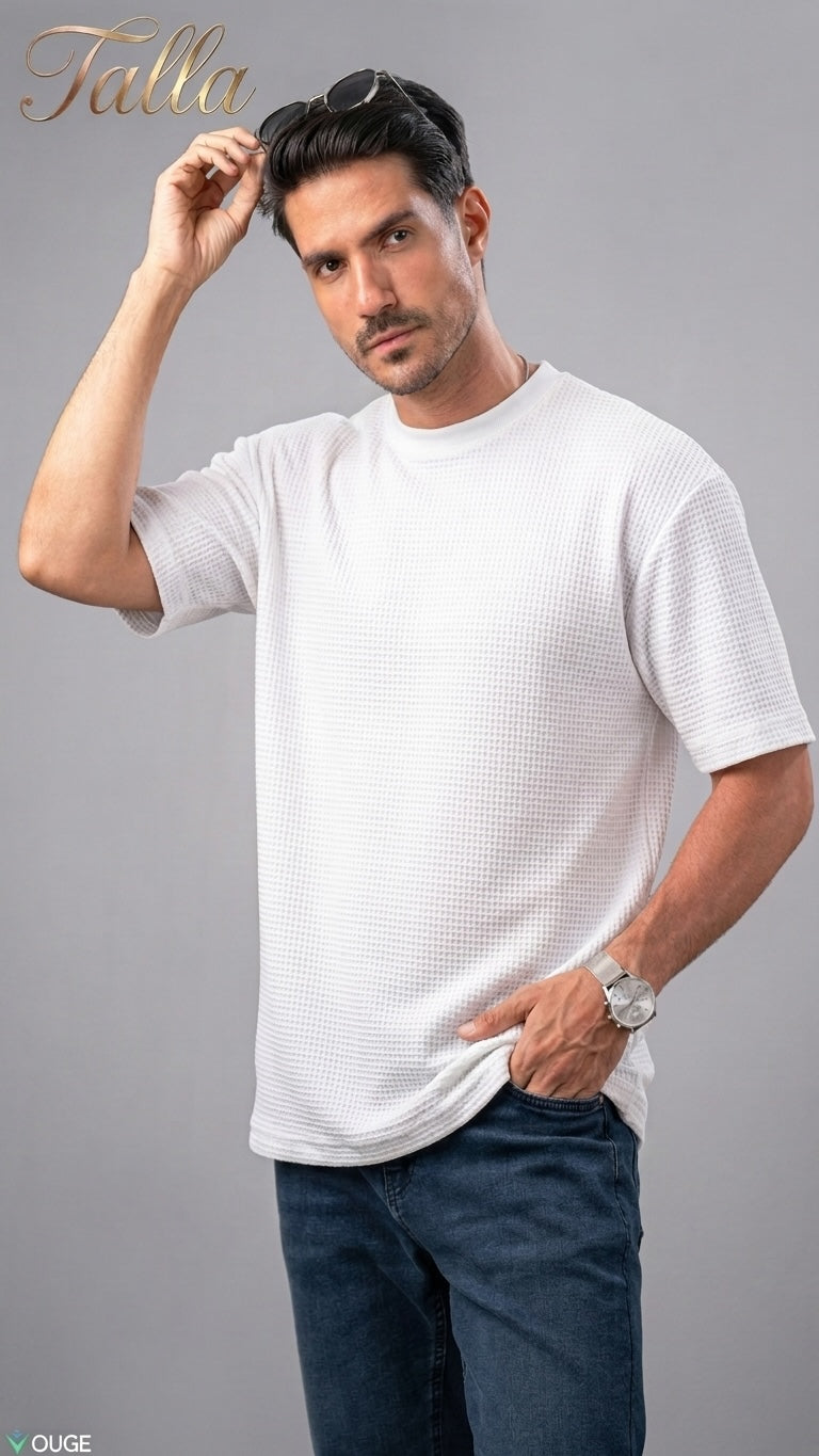 A model wearing a white Talla | طلةّ waffle-knit crew neck t-shirt with a relaxed fit and dark blue jeans.