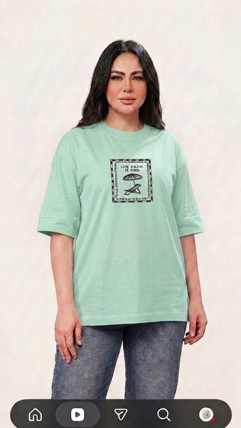 Talla | طلةّ mint green oversized cotton t-shirt with a vintage Cote d'Azur graphic print worn by a model.