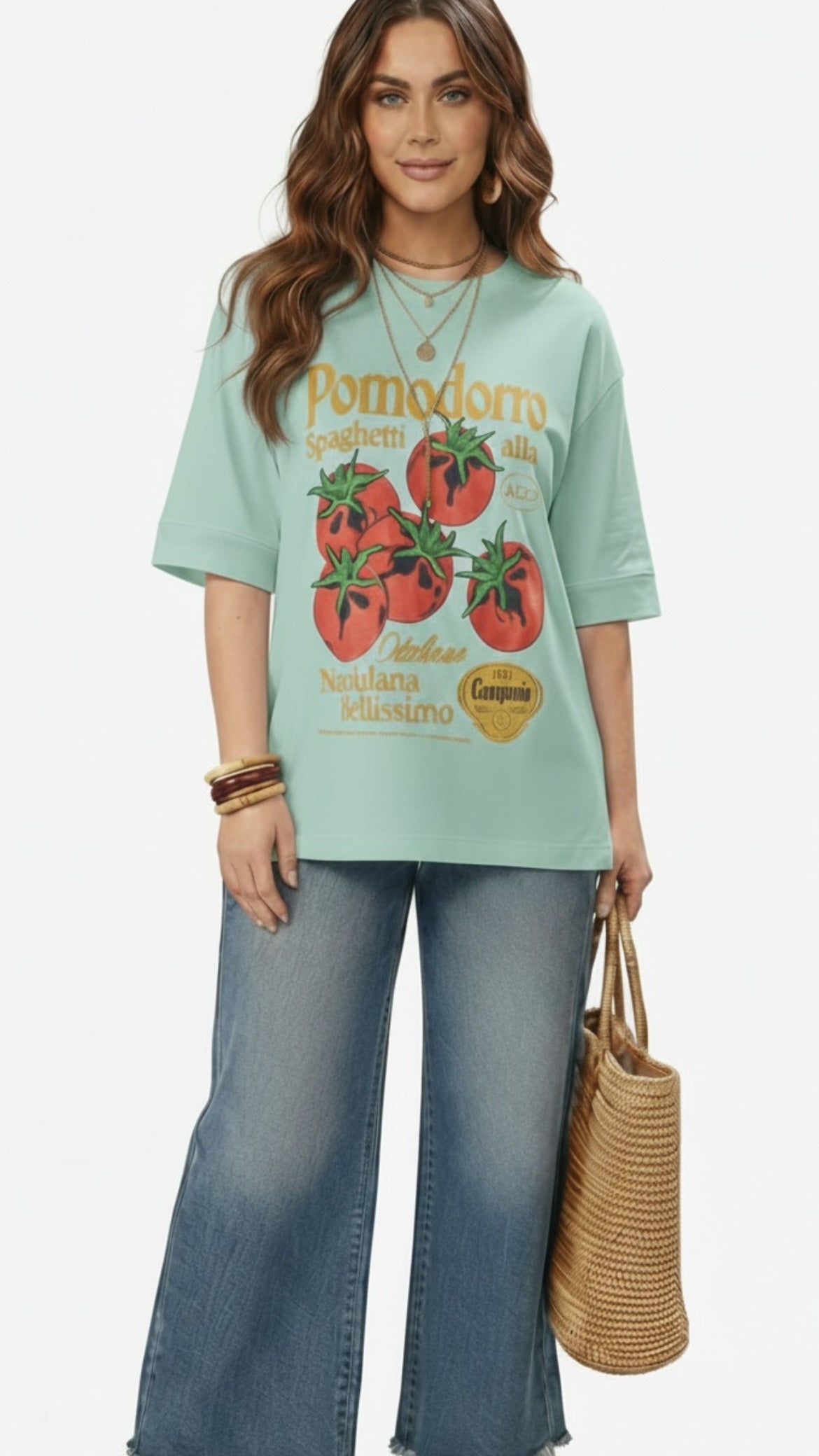 Talla | طلةّ oversized mint green cotton t-shirt with a vintage tomato graphic print worn by a woman with jeans.