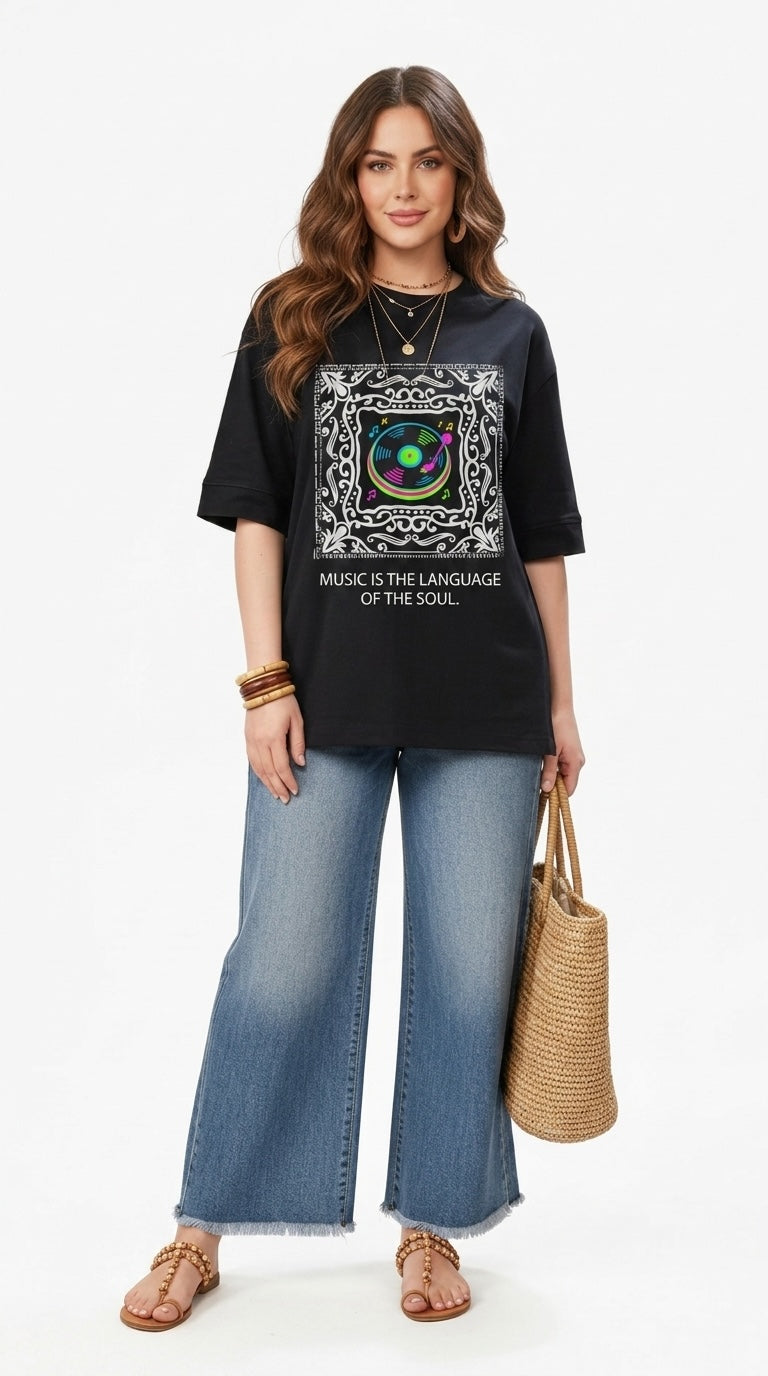 Talla | طلةّ oversized black graphic t-shirt with a record player print and music slogan, worn with wide-leg jeans.