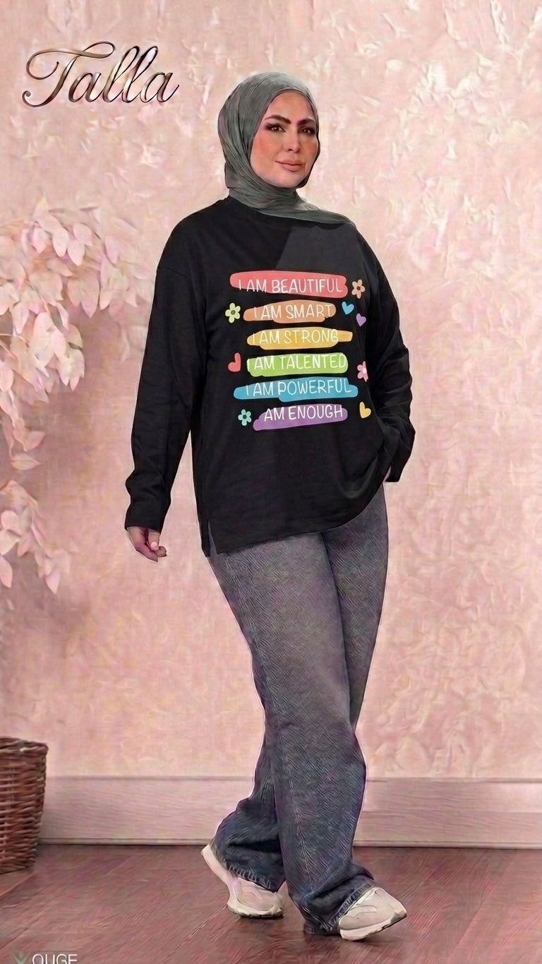 Talla | طلةّ black long sleeve sweatshirt with colorful affirmation graphic print worn by a woman in a grey hijab