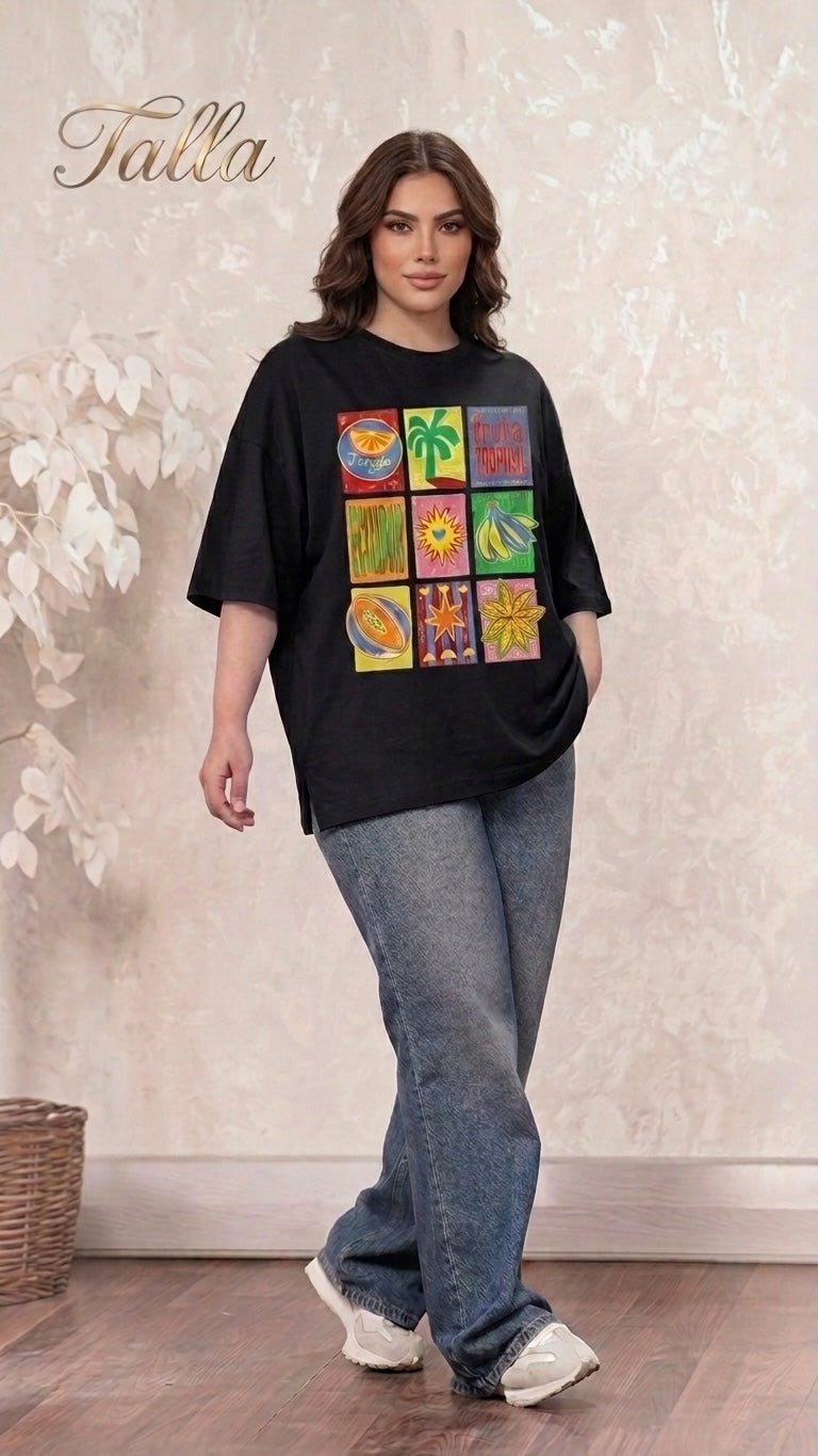 Model wearing a Talla | طلةّ black oversized t-shirt with a colorful tropical graphic print and blue denim jeans.