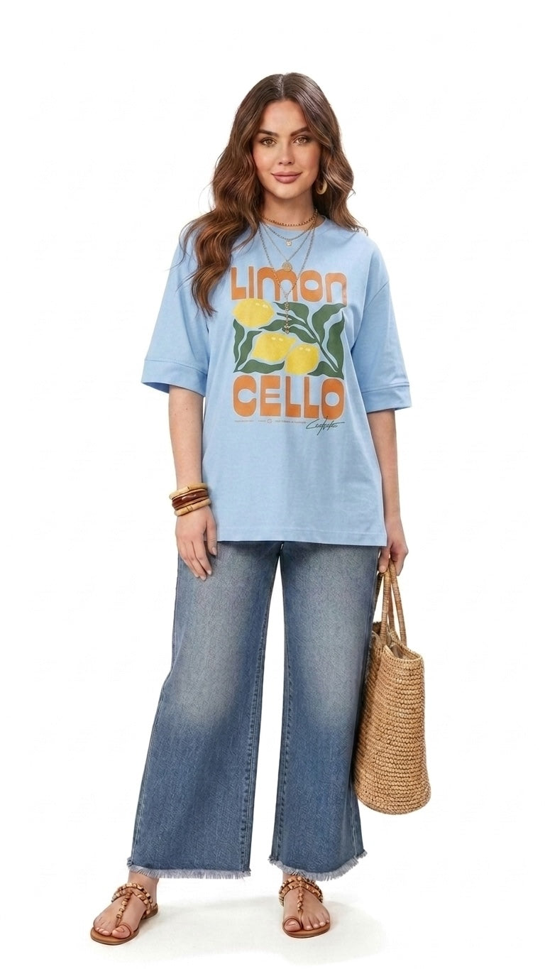 Talla | طلةّ light blue oversized cotton t-shirt with Limoncello graphic print, worn with wide-leg denim jeans.