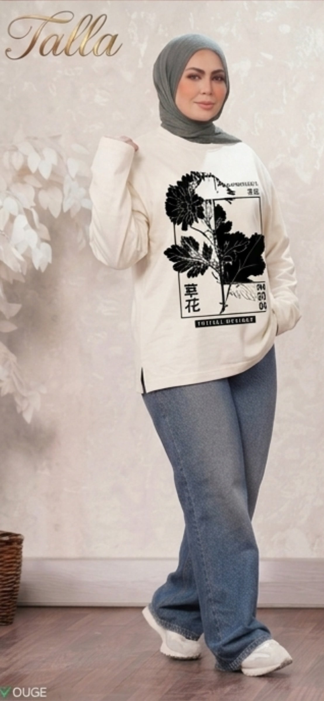 Talla | طلةّ cream cotton top featuring a black floral graphic print and side slits, worn with blue jeans and a hijab.