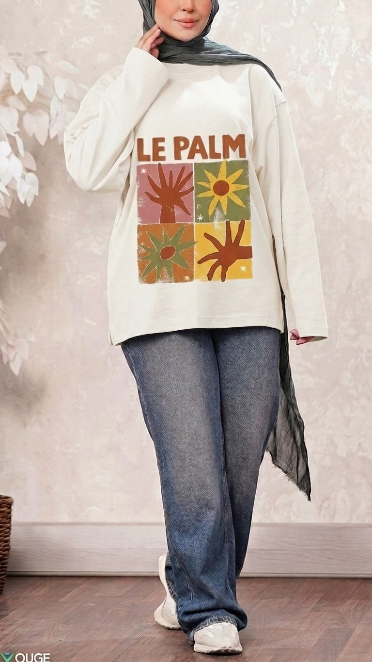 Talla | طلةّ cream long sleeve sweatshirt with Le Palm graphic print, crew neck, and drop shoulders worn with jeans.