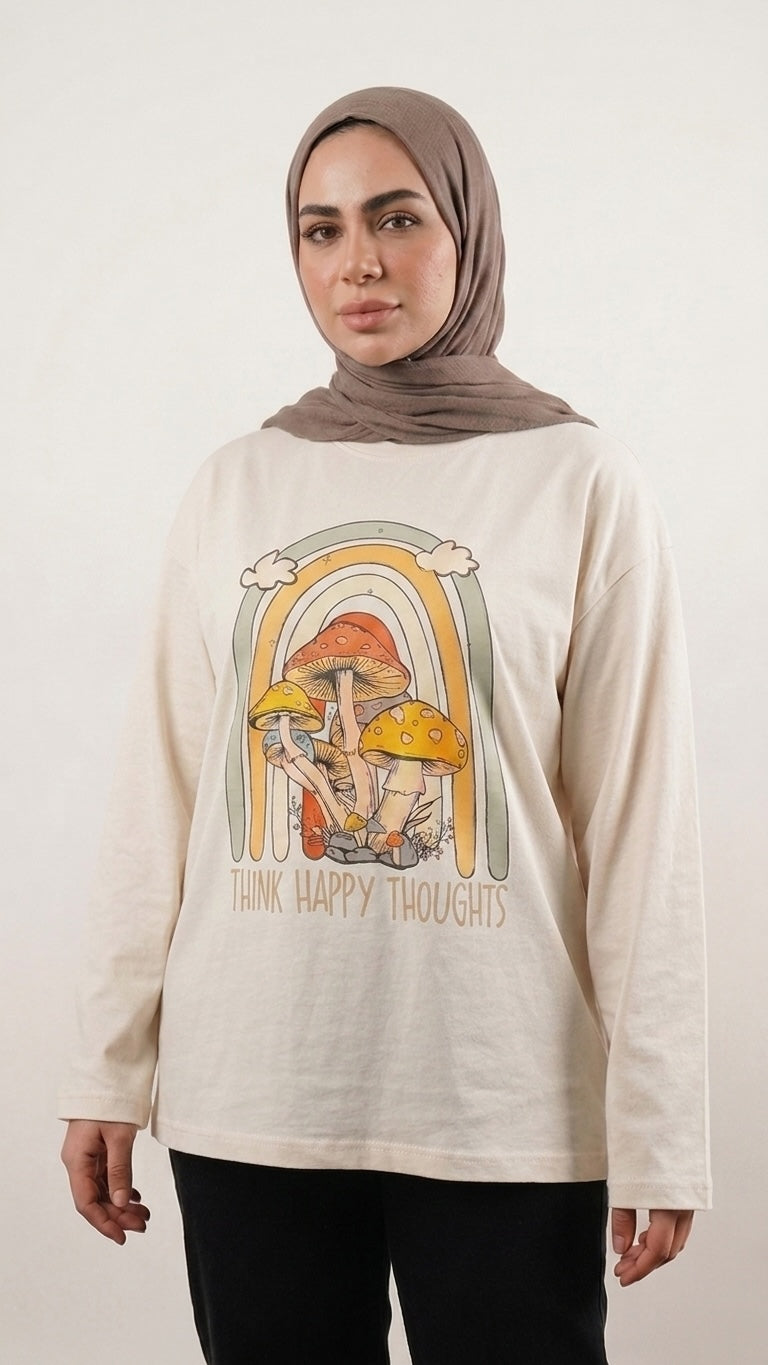 Talla | طلةّ long-sleeve cream cotton t-shirt featuring a retro mushroom and rainbow graphic with Think Happy Thoughts text