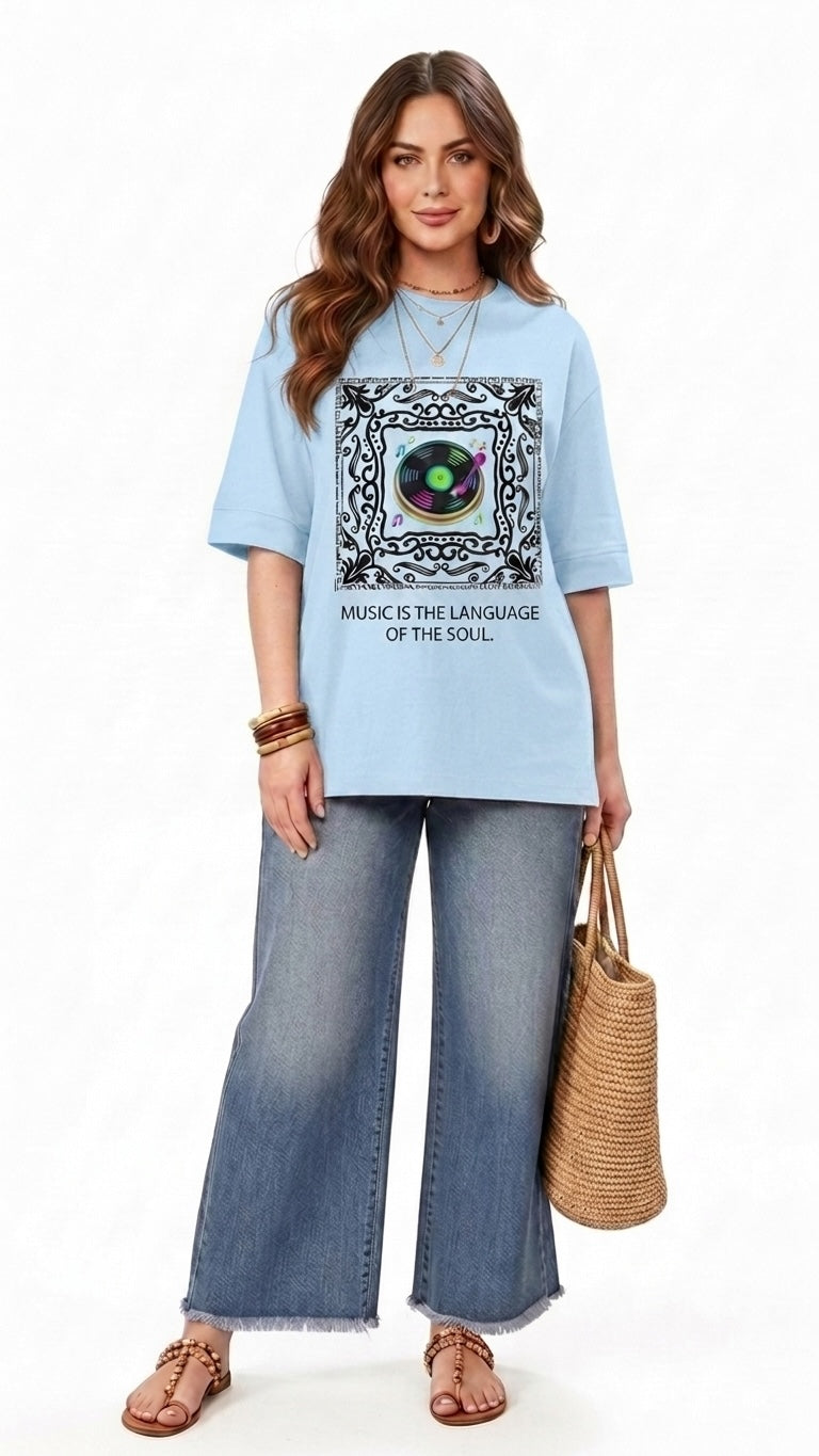 Talla | طلةّ light blue oversized graphic t-shirt with a record player print and music slogan on a female model.