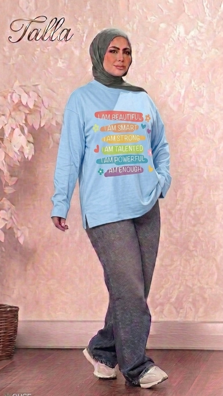 Talla | طلةّ light blue crew neck sweatshirt with colorful empowering affirmations, worn by a woman in a hijab.