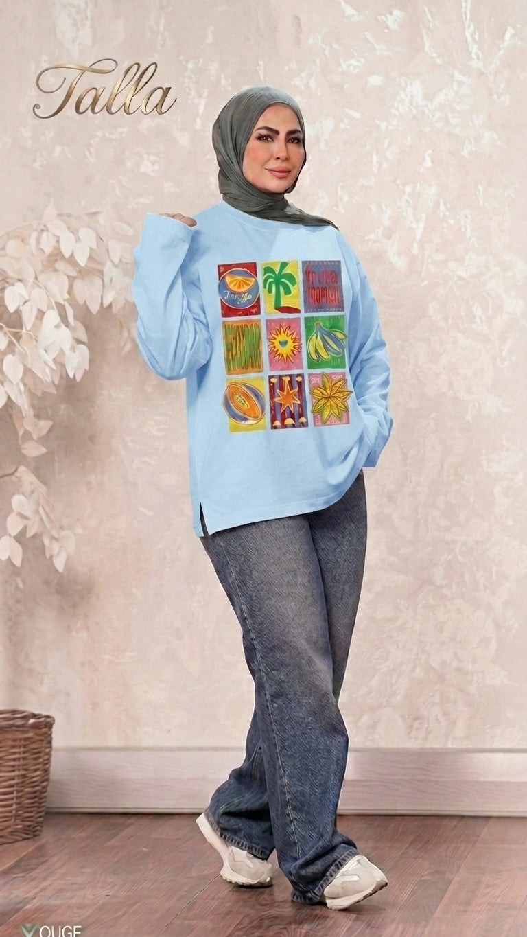 Talla | طلةّ light blue long sleeve sweatshirt with tropical fruit grid graphic print worn by a woman in a hijab