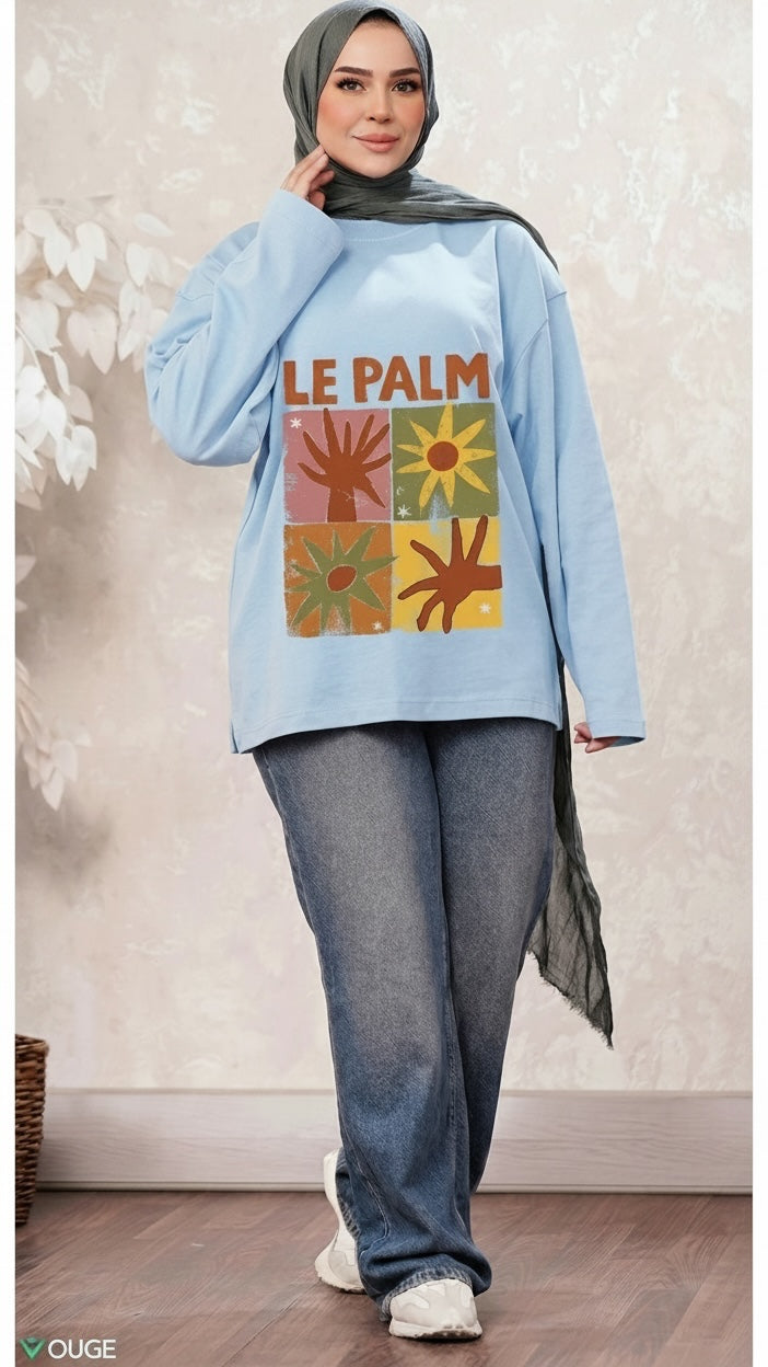 Talla | طلةّ light blue oversized sweatshirt with retro Le Palm graphic print worn by a woman in a grey hijab and jeans