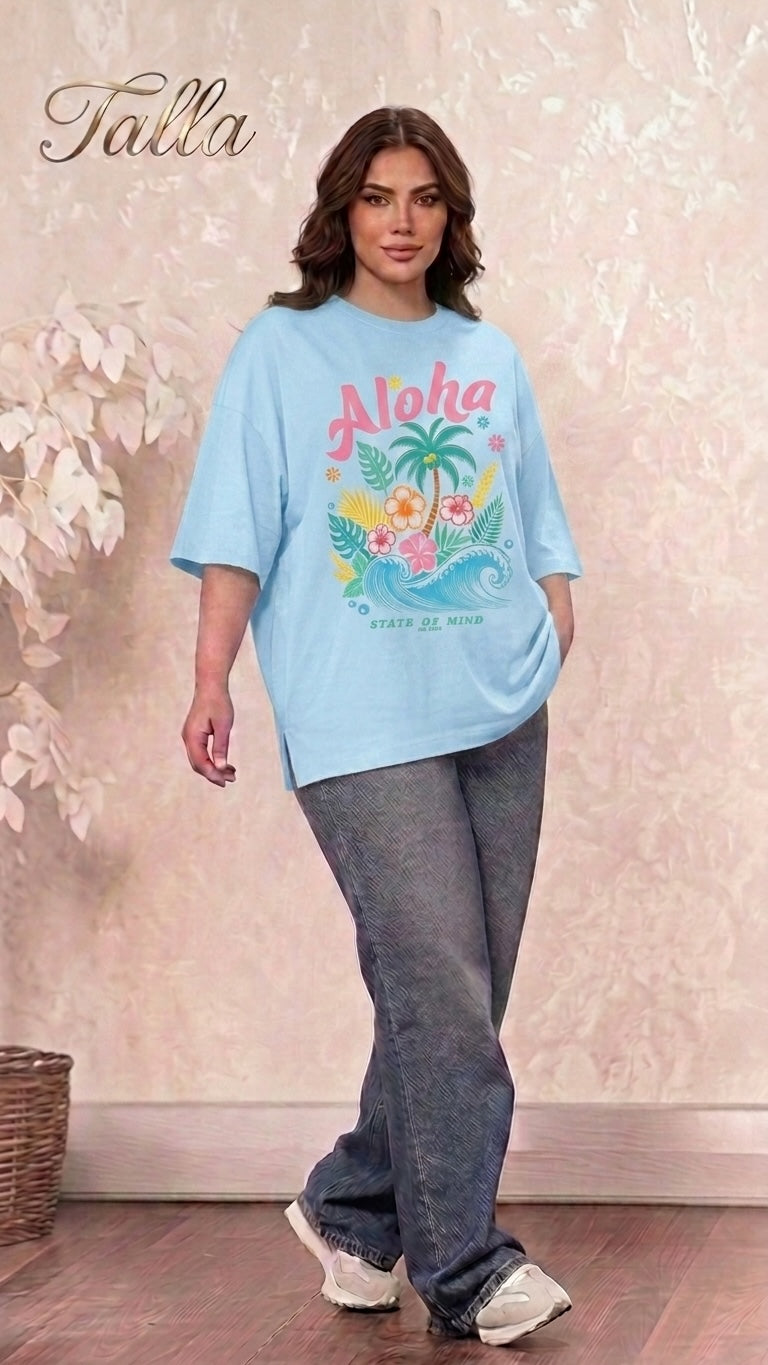 Talla | طلةّ light blue oversized graphic t-shirt with tropical palm tree and hibiscus print worn by a woman