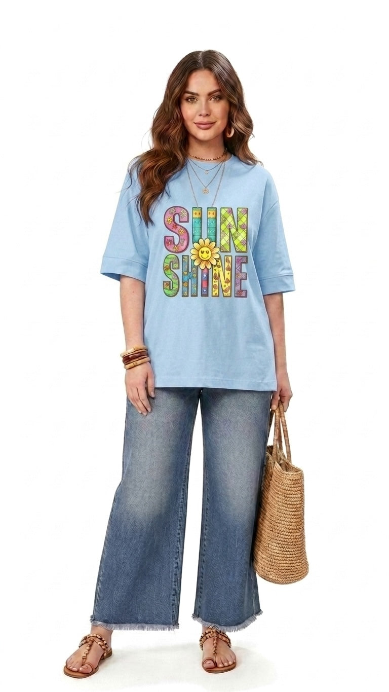 Model wearing a Talla | طلةّ light blue relaxed-fit graphic t-shirt with SUNSHINE text and sunflower print.