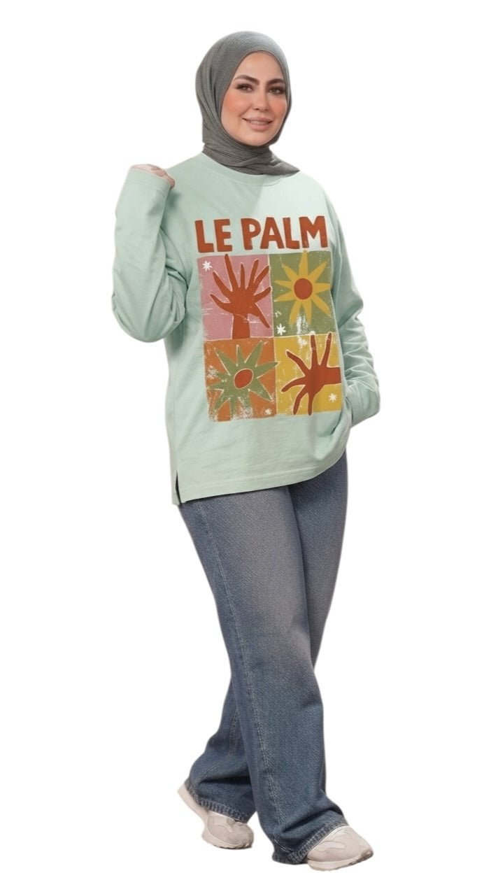 Talla | طلةّ mint green long sleeve sweatshirt with retro Le Palm grid graphic print worn by a woman in a hijab.