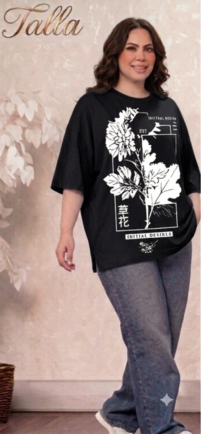 Talla | طلةّ oversized black t-shirt with white floral graphic print, crew neck, and side slits on a smiling model.