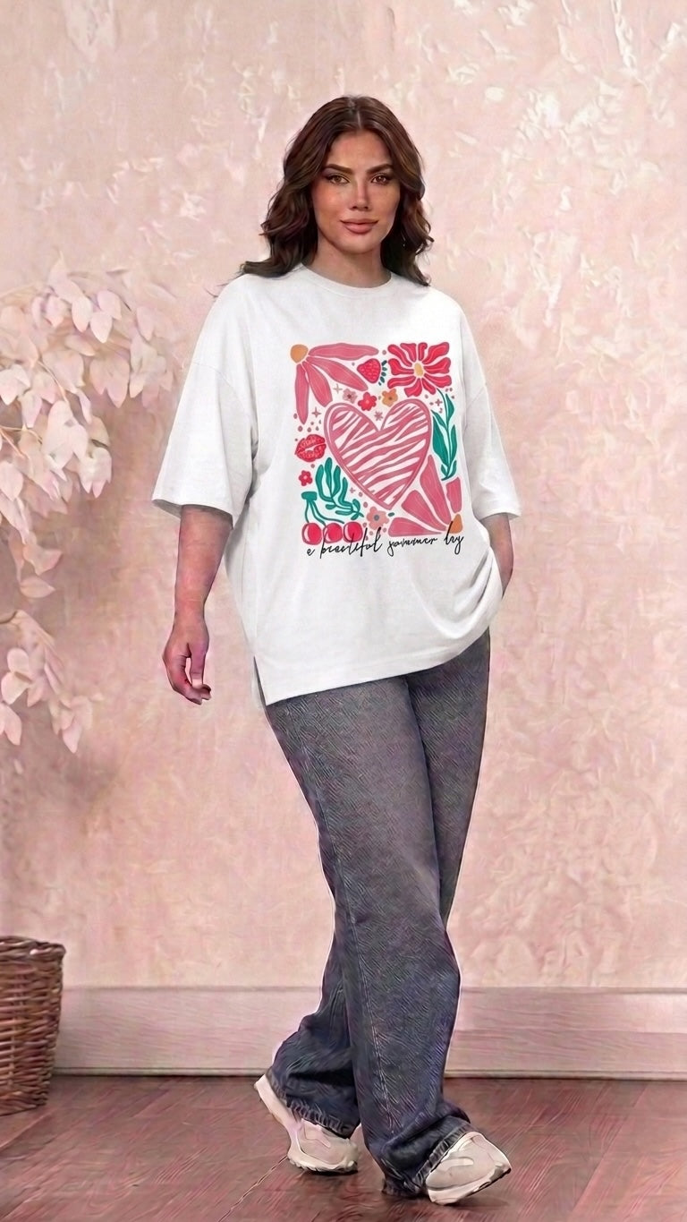 Talla | طلةّ oversized white graphic t-shirt with heart and floral print worn by a woman with dark jeans and sneakers