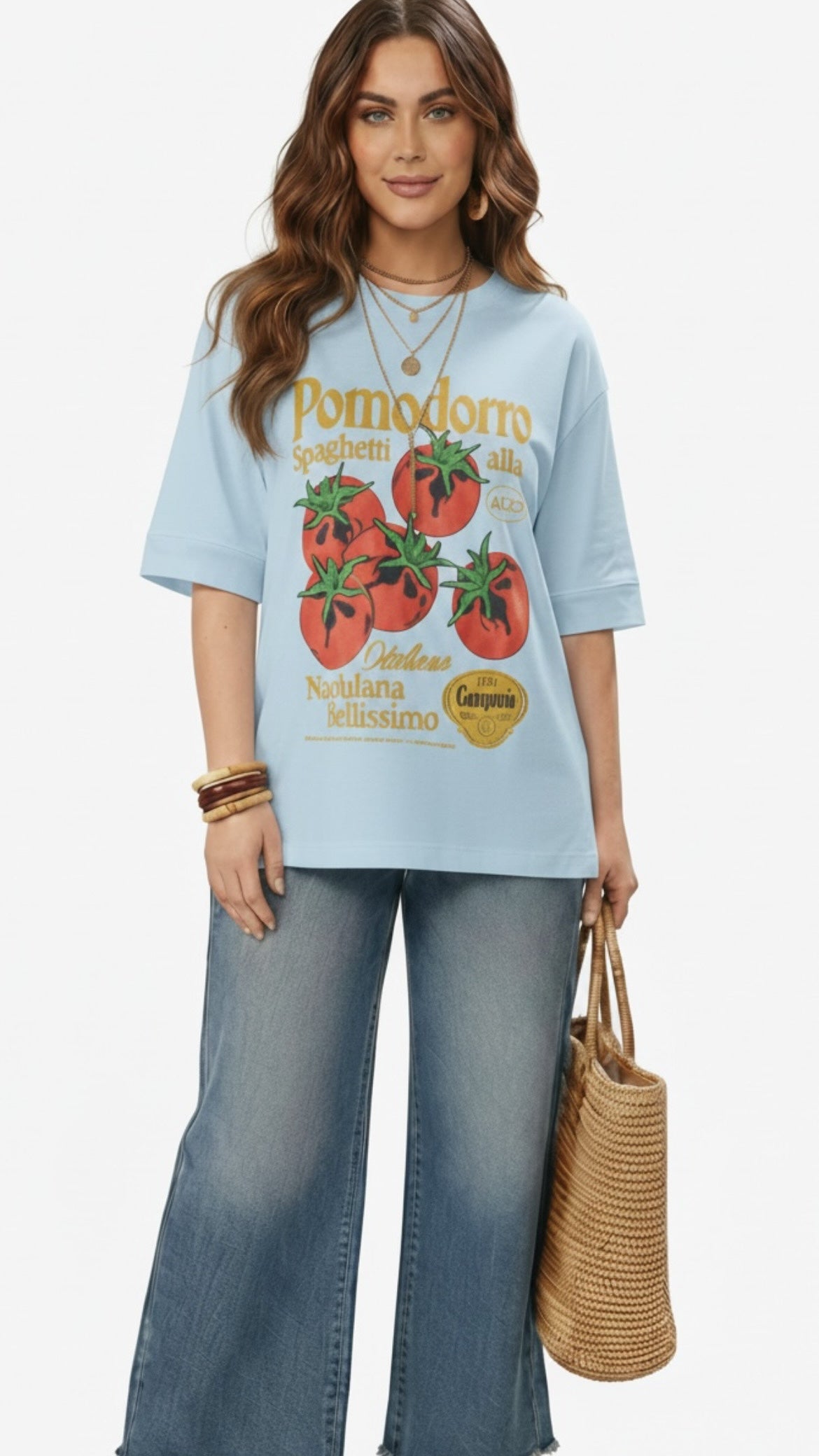 Talla | طلةّ oversized light blue cotton t-shirt with a vintage tomato graphic print worn by a woman with jeans.