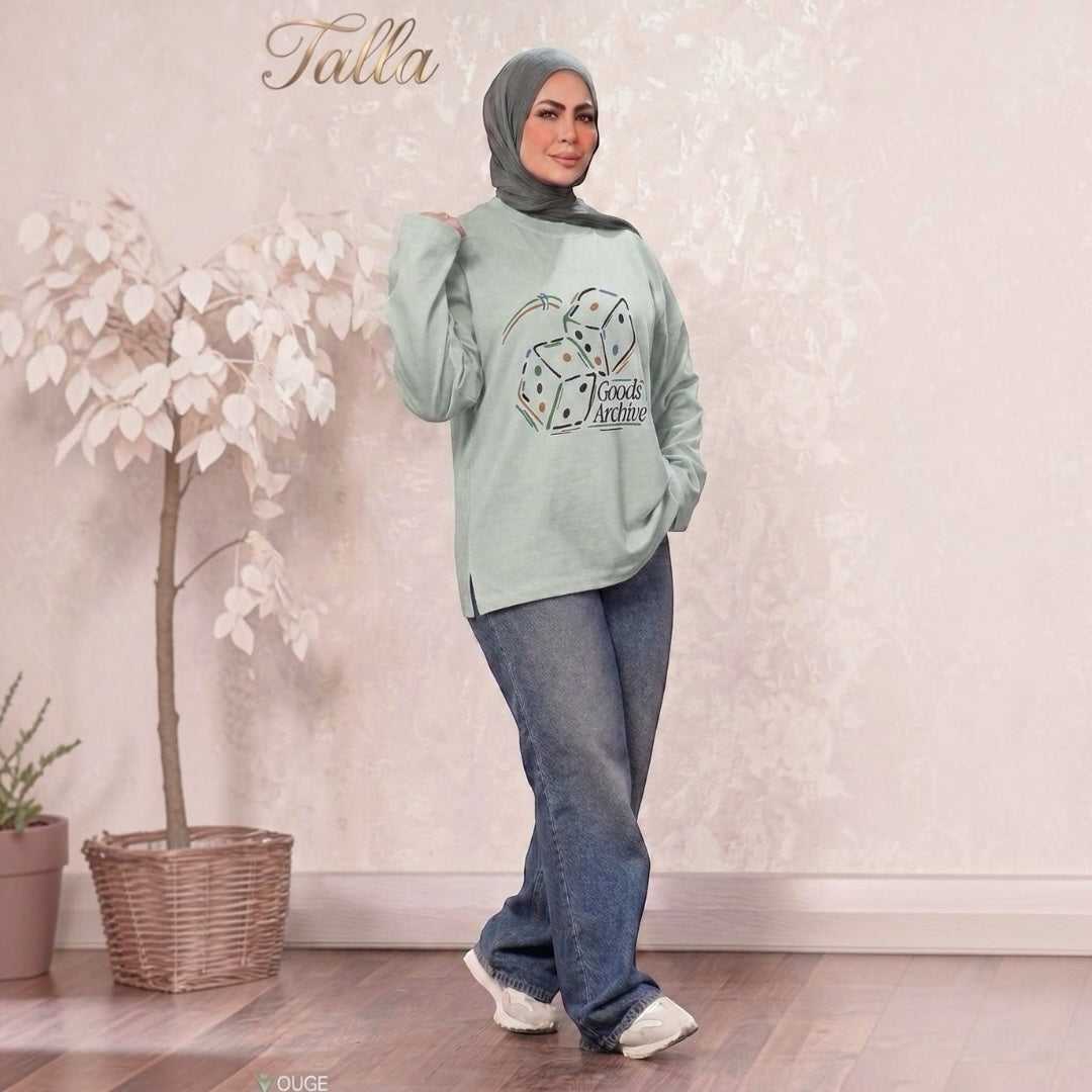 Talla | طلةّ sage green crewneck sweatshirt with Goods Archive dice graphic, worn by a model with a matching hijab.