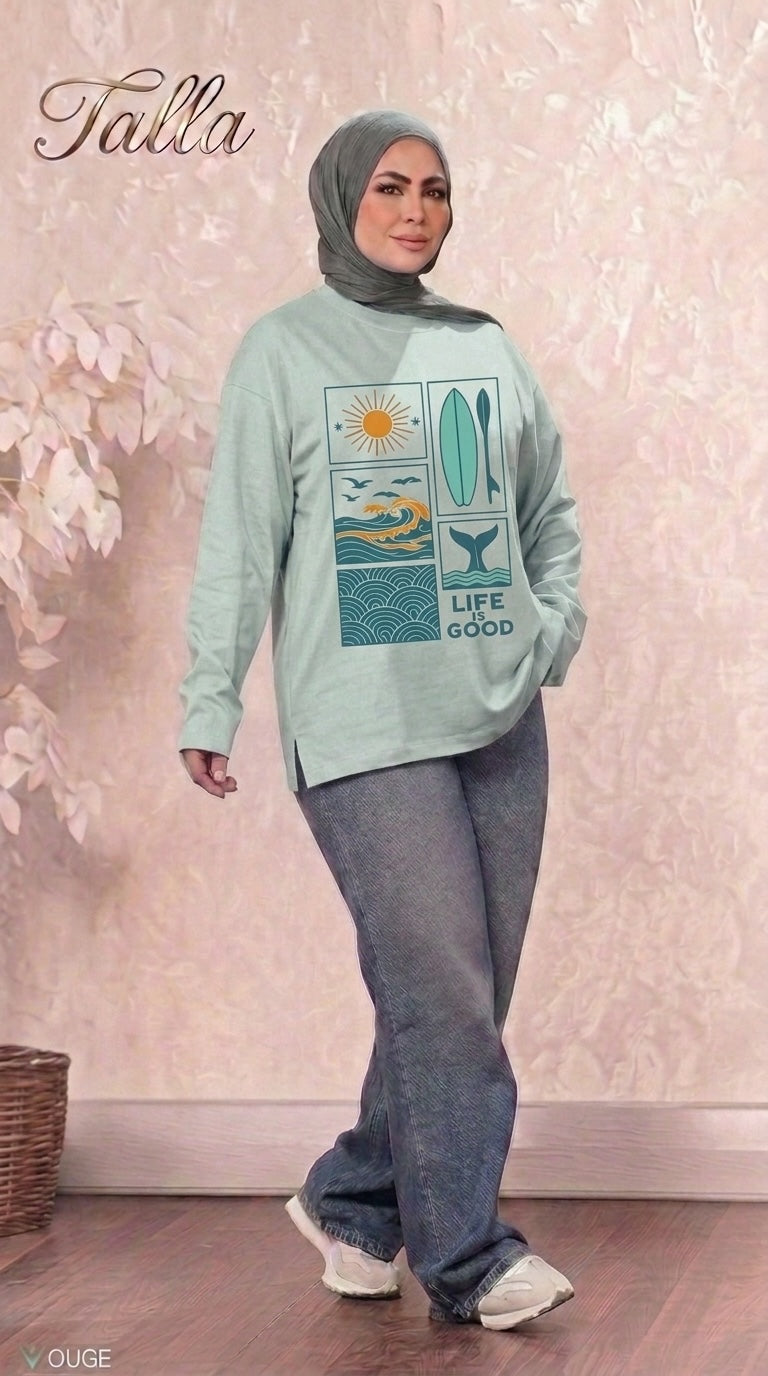 Talla | طلةّ sage green long sleeve sweatshirt with Life is Good coastal graphic print worn by a woman in a hijab.