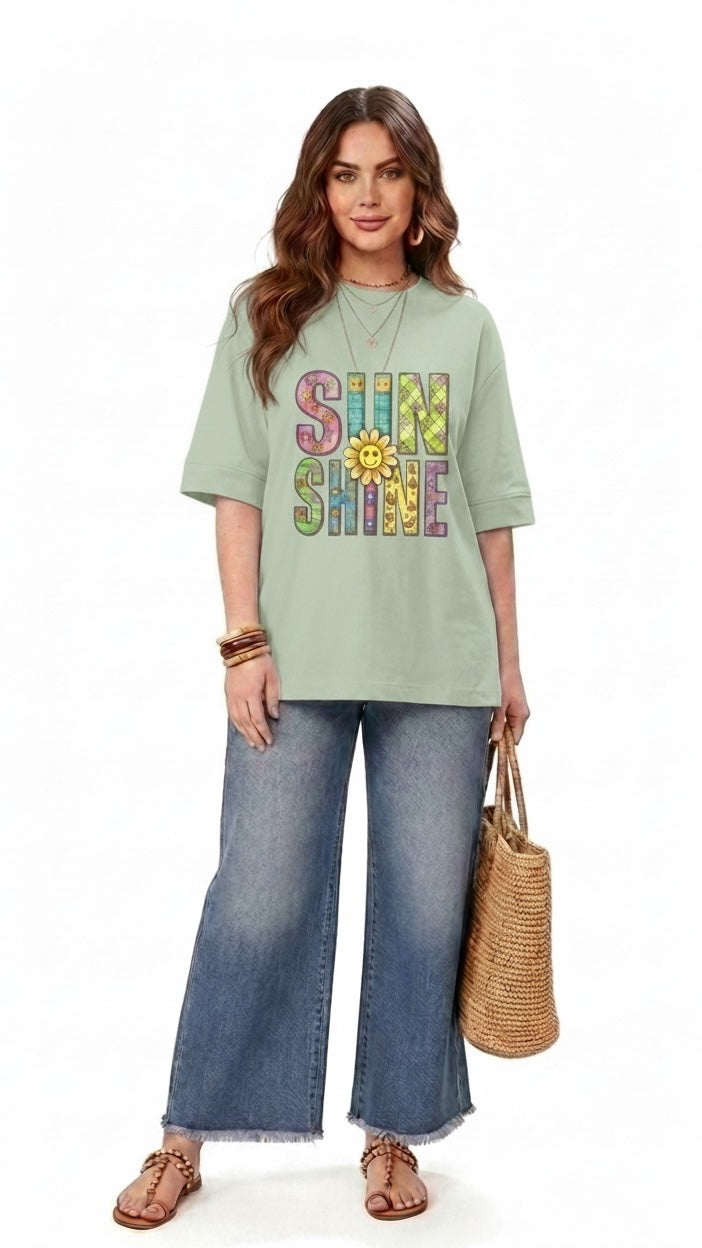Model wearing a Talla | طلةّ sage green relaxed-fit t-shirt with a colorful SUNSHINE graphic and sunflower print.