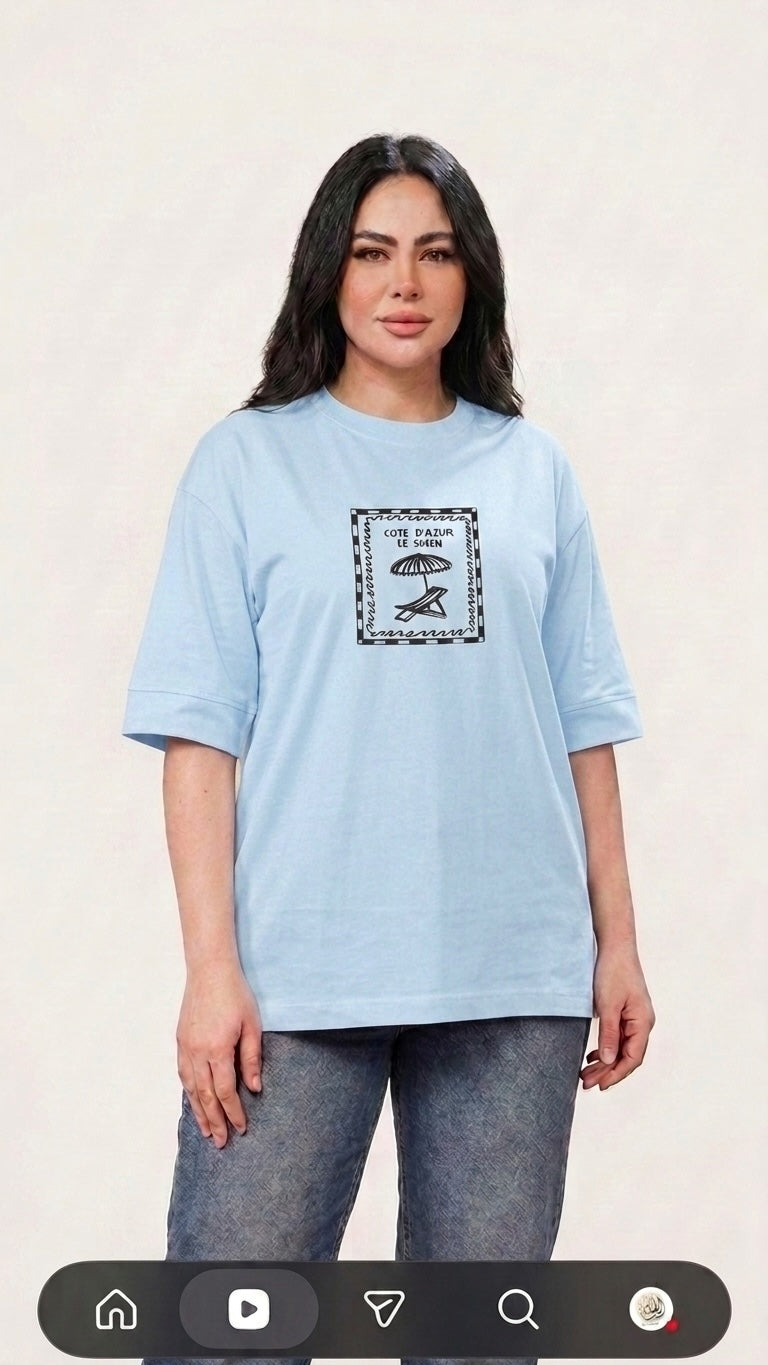 Talla | طلةّ sky blue oversized cotton t-shirt with a vintage-inspired Cote d'Azur beach graphic print.