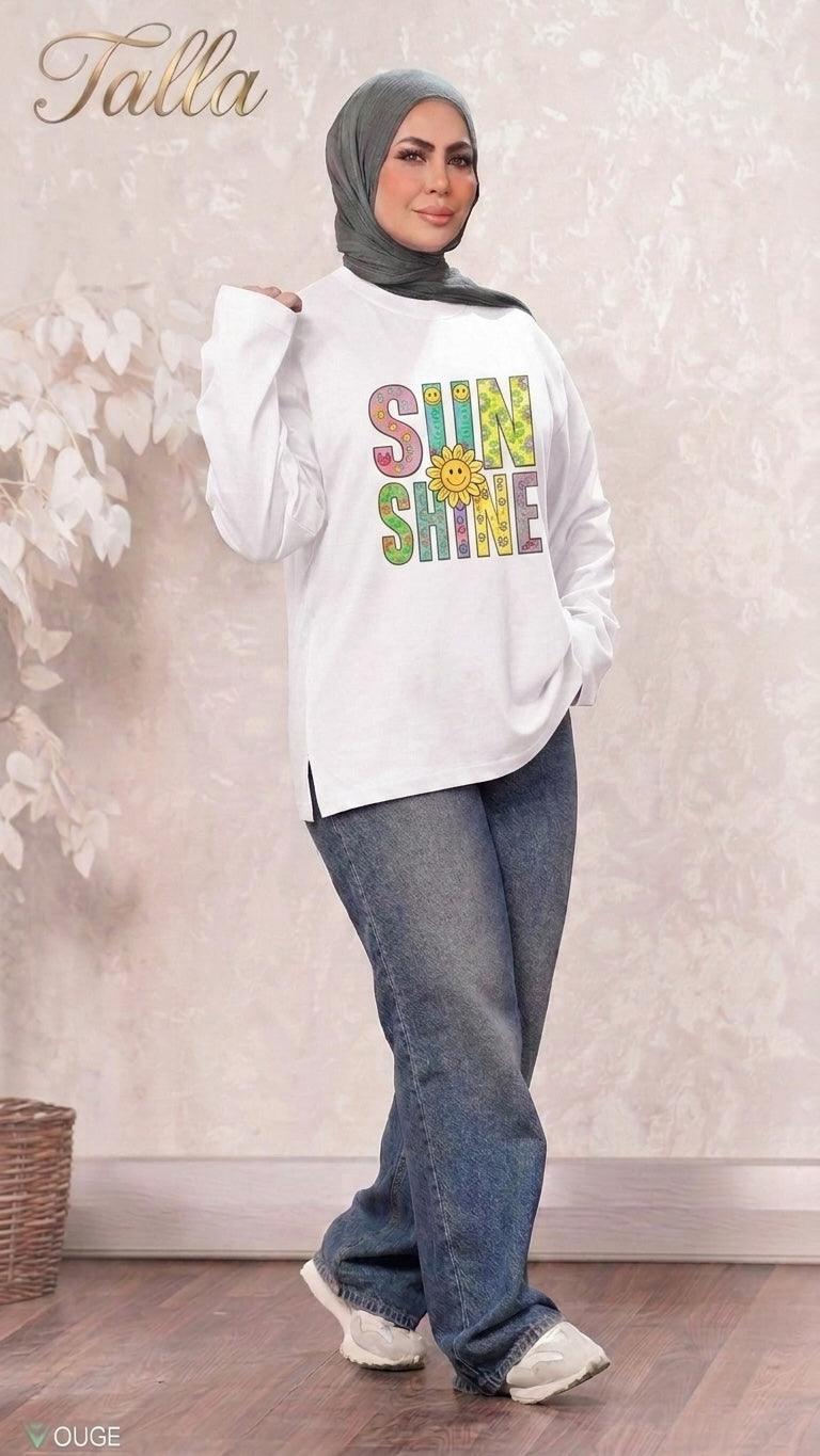 Talla | طلةّ white long-sleeve sweatshirt with colorful SUNSHINE graphic, worn by a woman in a hijab and jeans.