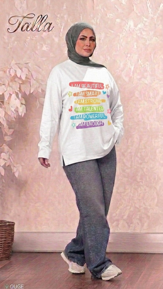 Talla | طلةّ white long sleeve sweatshirt with colorful affirmation graphic print worn by a woman in a grey hijab