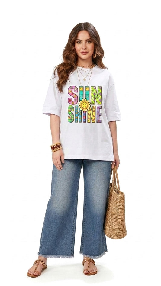 Talla | طلةّ white graphic t-shirt with SUNSHINE text and sunflower print worn by a woman with wide-leg denim jeans.